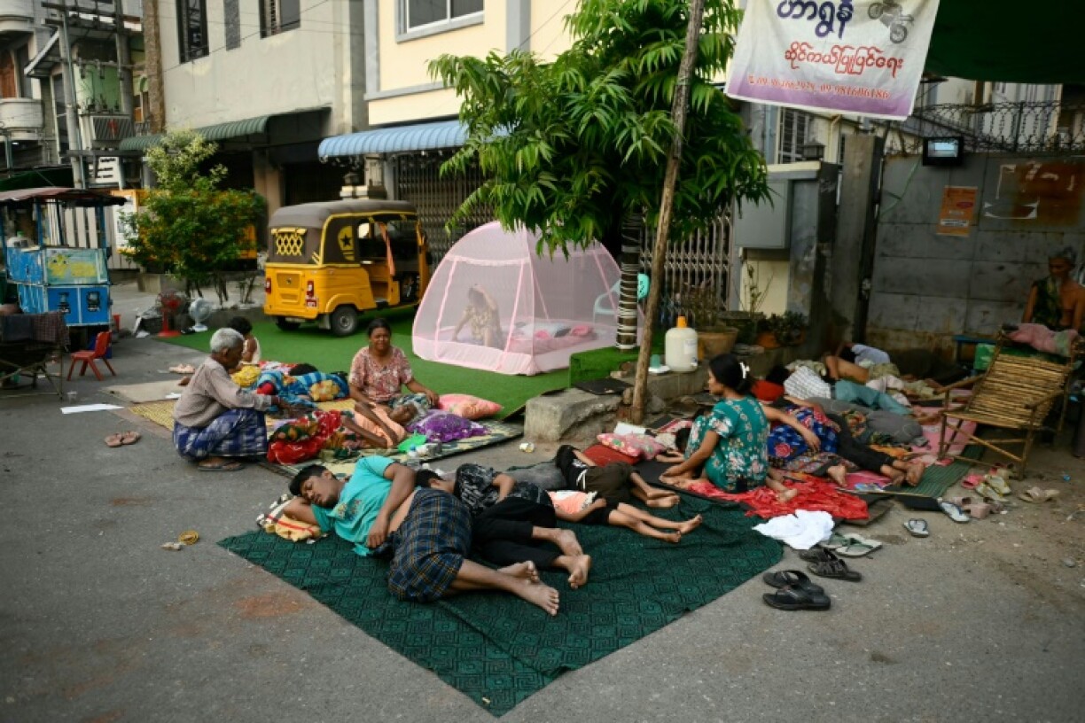 People sleep in the open on the ground in Mandalay after an earthquake left thousands homeless