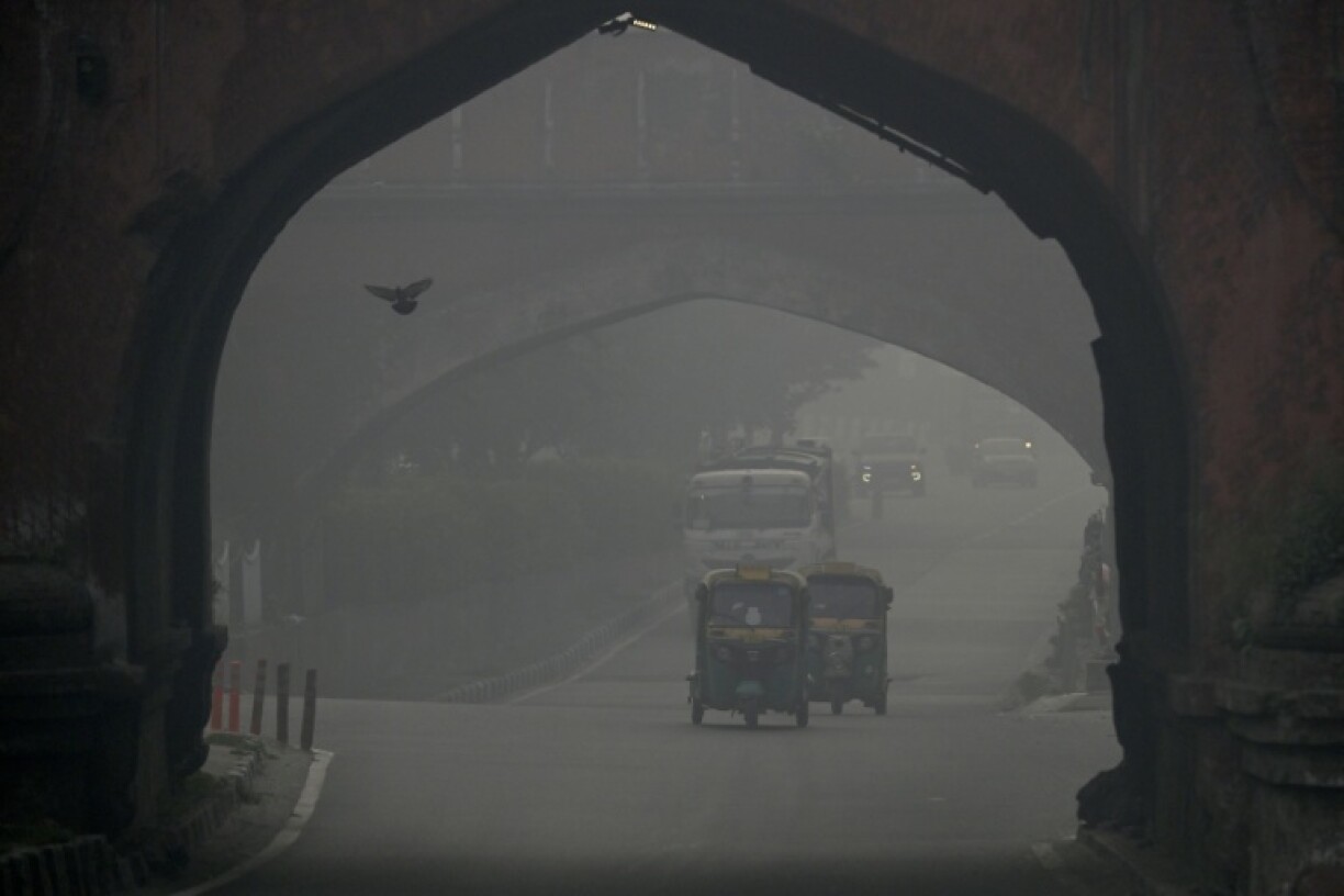 Commuters drive amid heavy smog in New Delhi on October 21, 2025, as haze engulfed the city skyline after Diwali celebrations