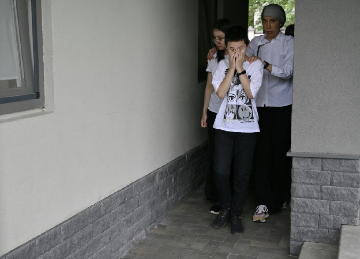 Natalya Sadykova and her children at the funeral on the outskirts of Kyiv
