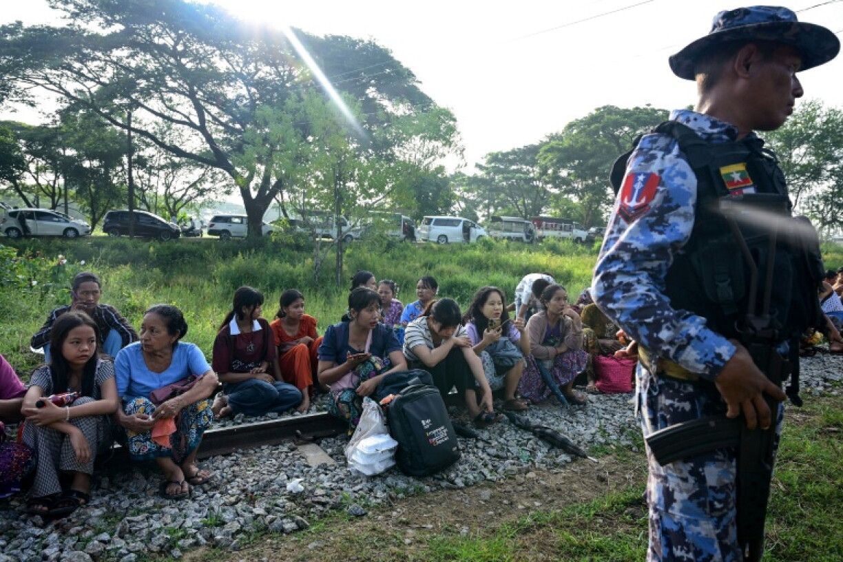 Family members wait outside the Myanmar Navy base in Thanlyin to welcome their loved ones returning from Malaysia