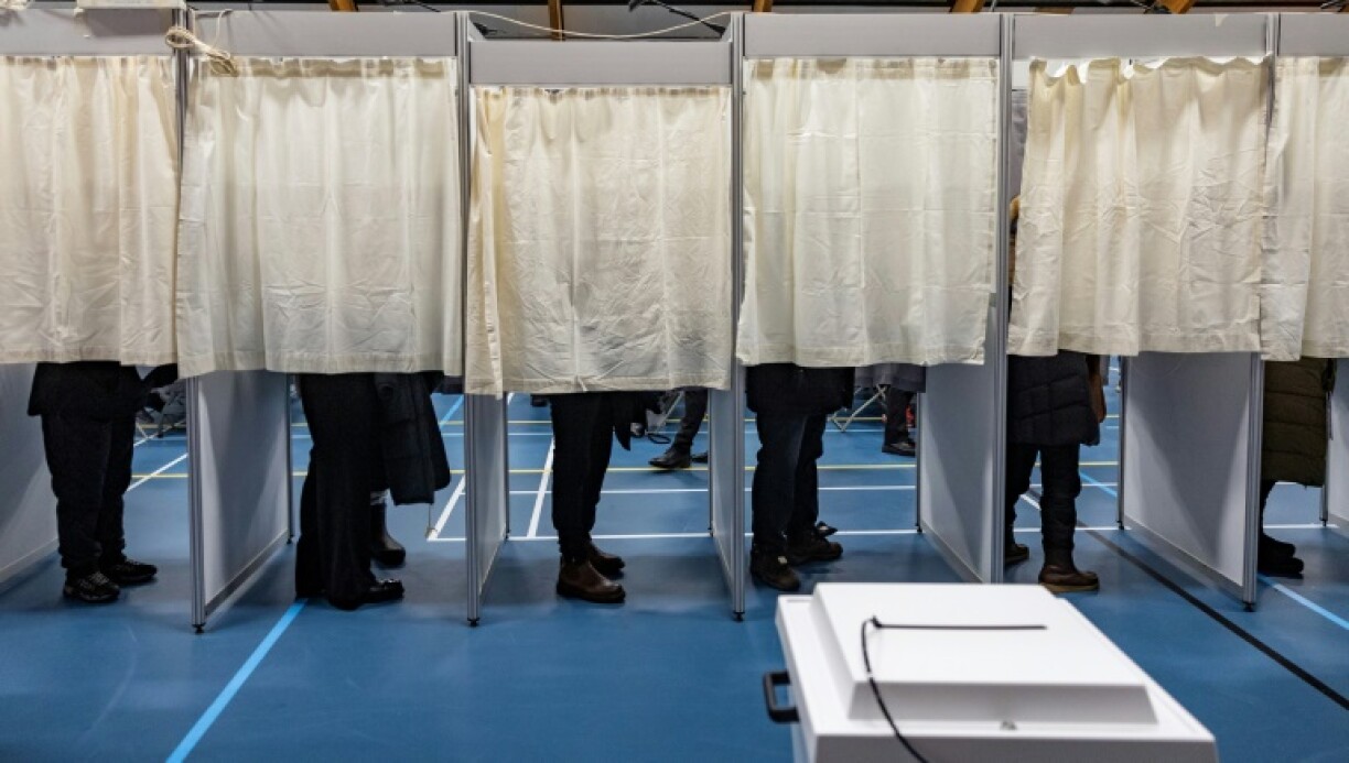 Des électeurs dans les isoloirs d'un bureau de vote à Nuuk, lors des législatives au Groenland, le 11 mars 2025