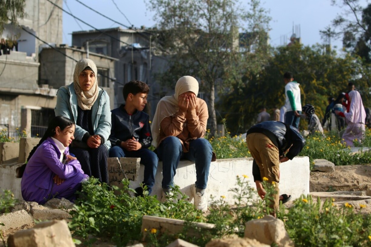 Palestinians visit the grave of a relative after Eid al-Fitr prayers, in the central Gaza Strip