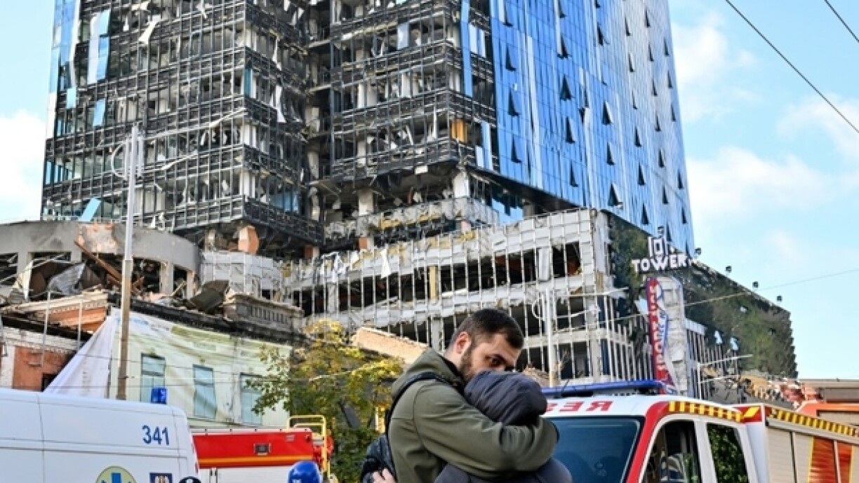 Deux personnes s'enlacent devant un immeuble détruit, après de multiples frappes russes sur Kiev, la capitale de l'Ukraine, le 10 octobre 2022