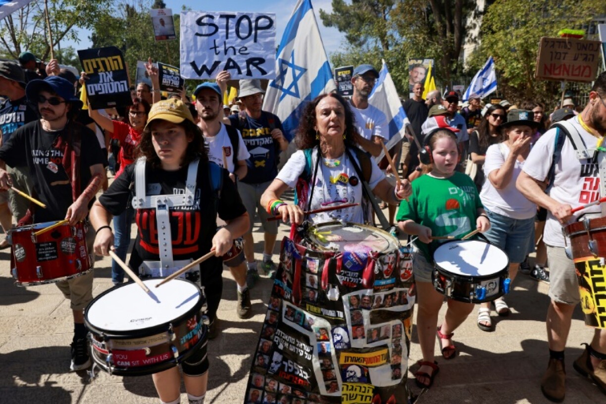 Des familles d'otages retenus dans la bande de Gaza et personnes les soutenant brandissent des panneaux et drapeaux israéliens lors d'une manifestation appelant à les libérer, à Jérusalem, le 17 août 2025