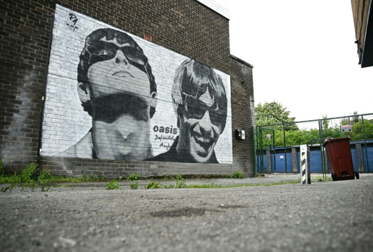 Street artwork depicting the Oasis brothers Liam and Noel Gallagher, created by Manchester-based street artist, Pic.One.Art, pictured in August 2024 on the side of Sifters Record store in Burnage, Manchester