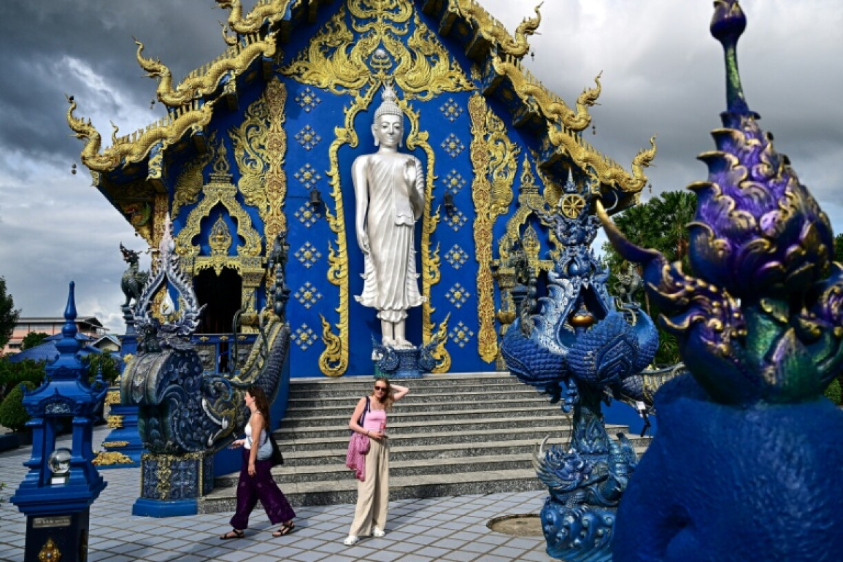 Des touristes visitent le temple bouddhiste Wat Rong Suea Ten, dit "Temple Bleu", dans la province de Chiang Rai, au nord de la Thaïlande, le 26 mai 2025
