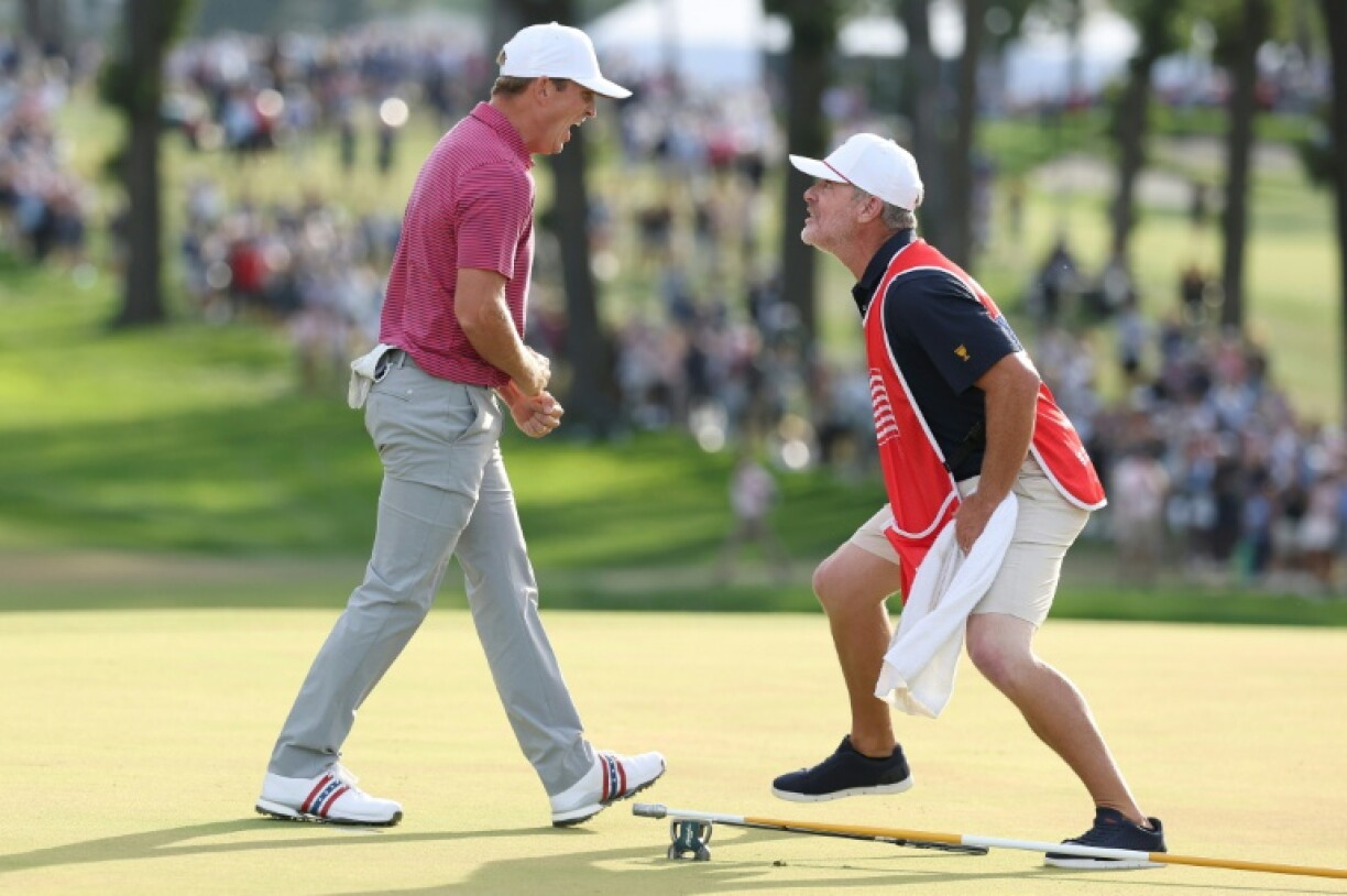 Jacob Bridgeman, left, and acaddie GW Cable react on the 18th green at Medinah after Bridgeman sank the putt that clinched an 11th consecutive Presidents Cup triumph