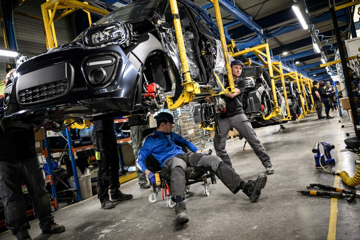Des salariés travaillent sur la chaîne de production de voitures électriques dans l'usine du groupe Ligier, dans l'ouest de la France