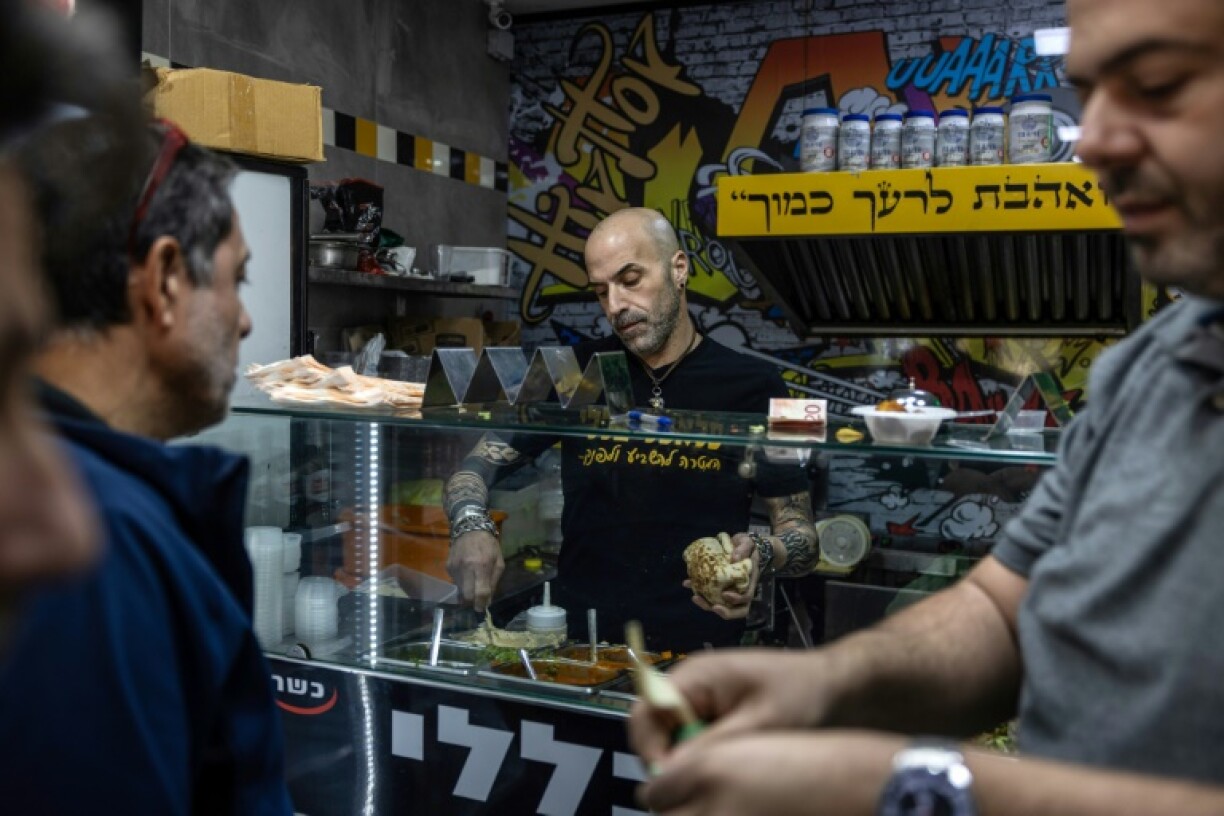 At Baleli Falafel, Yonatan Baleli stuffed pita with salad and tahini as a long line of hungry customers waited to blaring trance music