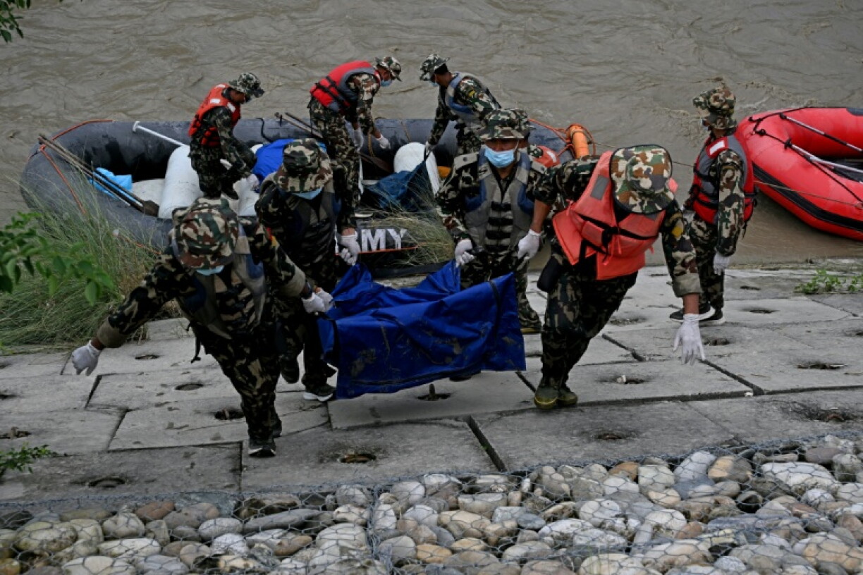 Des soldats transportent les corps de victimes des inondations lors d'une opération de recherche le long de la rivière Narayani, à Bharatpur, dans le district de Chitwan, le 31 août 2026 au Népal