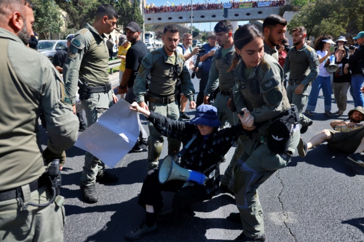Des membres des forces de sécurité évacuent une personne manifestant à Jérusalem pour réclamer la libération des otages retenus à Gaza, le 17 août 2025