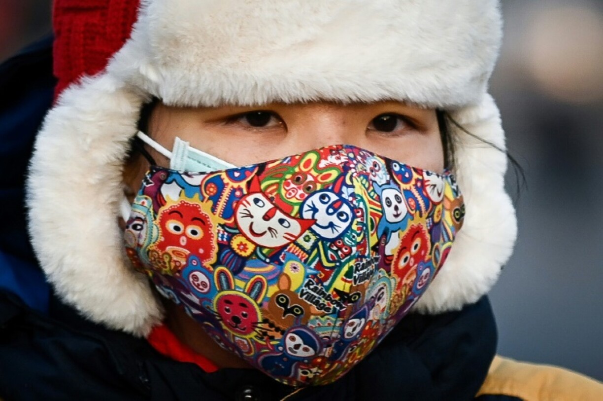 Une femme portant deux masques, dans une rue de Pékin, le 10 décembre 2020.