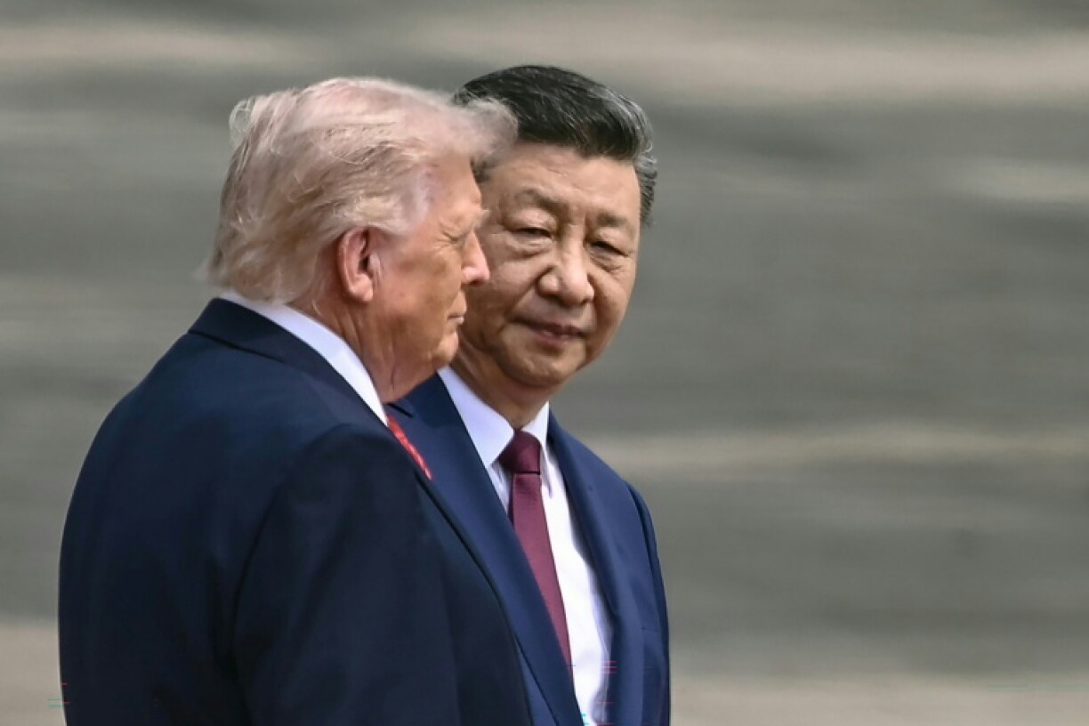 Le président chinois Xi Jinping (d) et le président américain Donald Trump lors d'une cérémonie d'accueil au Grand Palais du Peuple à Pékin, le 14 mai 2026