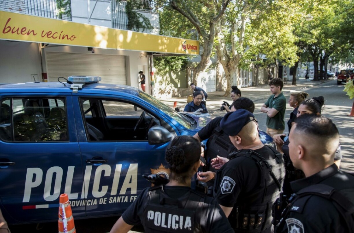 Des policiers devant un supermarché appartenant à la famille d'Antonela Roccuzzo, l'épouse de la star du football argentin Lionel Messi, après des tirs sur la façade des locaux fermés, le 2 mars 2023 à Rosario, dans la province de Santa Fe, en Argentine