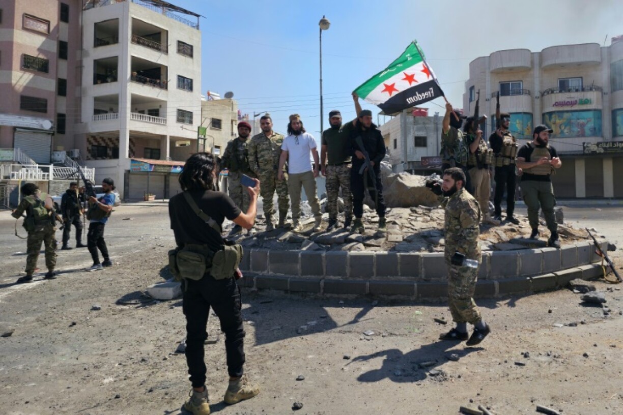 Government-aligned forces pose for a picture on a roundabout in Sweida on Tuesday
