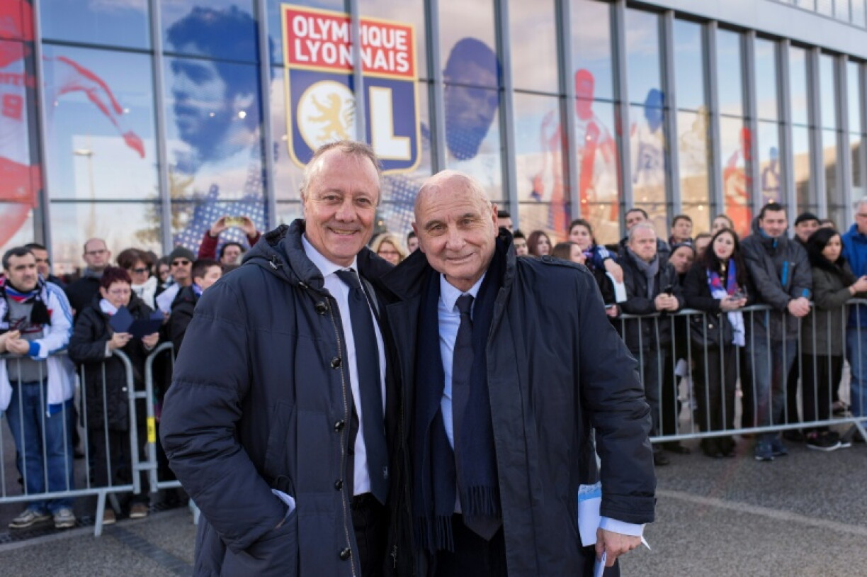 Fleury Di Nallo (D) et Bernard Lacombe, deux légendes de l'OL aujourd'hui décédés, posent devant l'entrée du stade du club situé à Décines-Charpieu, le jour de son inauguration, le 14 février 2016