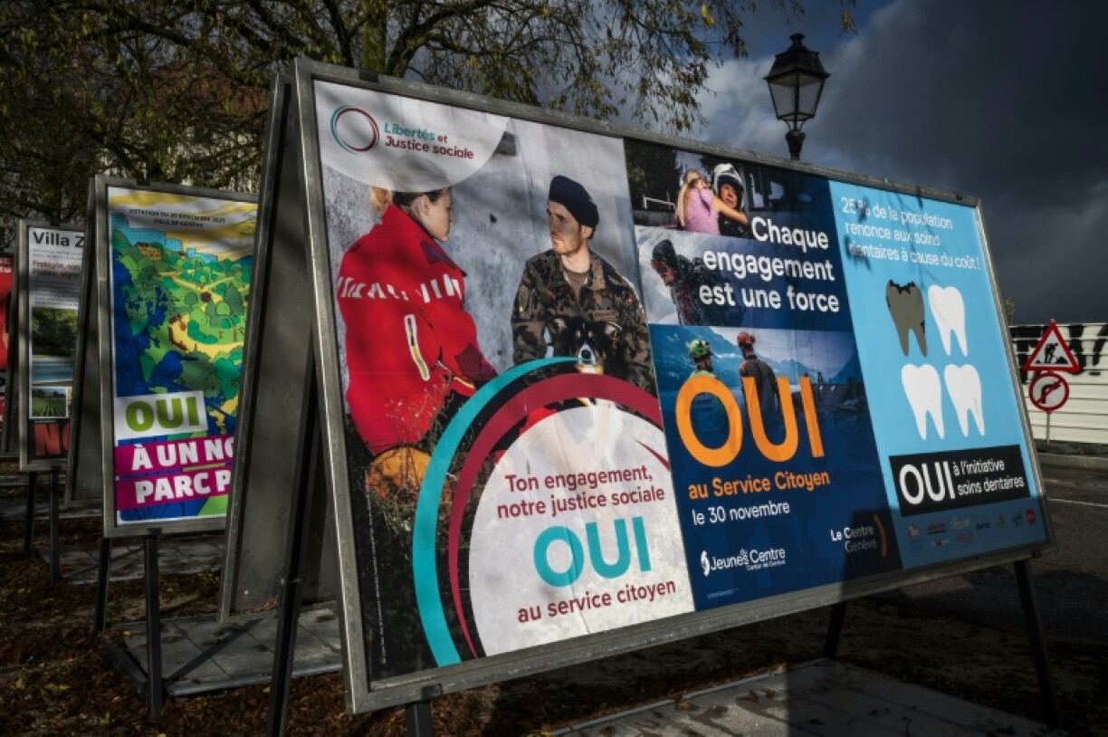 Des affiches électorales en faveur d'une initiative instaurant le devoir civique obligatoire pour tous dans une rue à Genève, le 25 novembre 2025 en Suisse