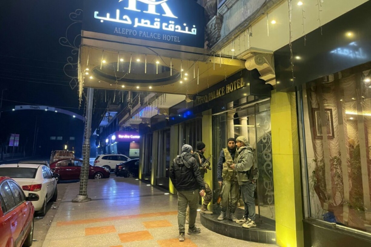 Anti-government fighters gather in front of a hotel in central Aleppo, Syria's second city which a war monitor said jihadist rebels now control most of