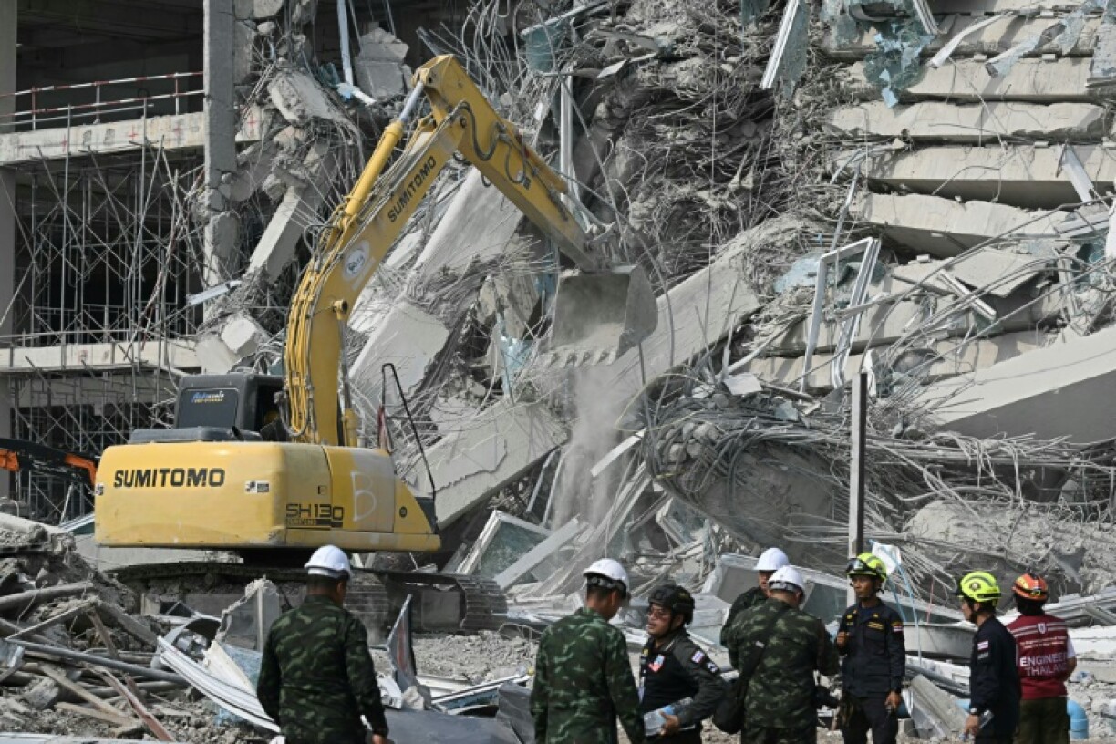 Un engin de chantier déblaie les décombres d'un immeuble en construction détruit par un puissant séisme, le 29 mars 2025 à Bangkok