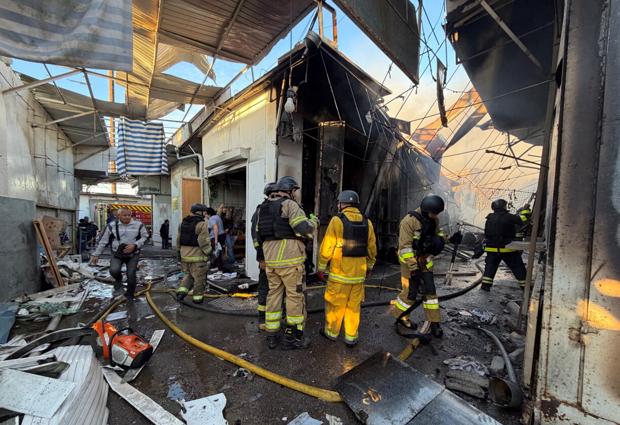 Des pompiers ukrainiens inspectent les dégâts sur un marché local à la suite d'une attaque de drone russe à Zaporijjia, le 26 septembre 2026.