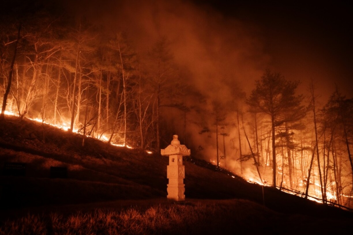 A wildfire is seen next to a stone lantern of a family tomb in Andong on March 26, 2025
