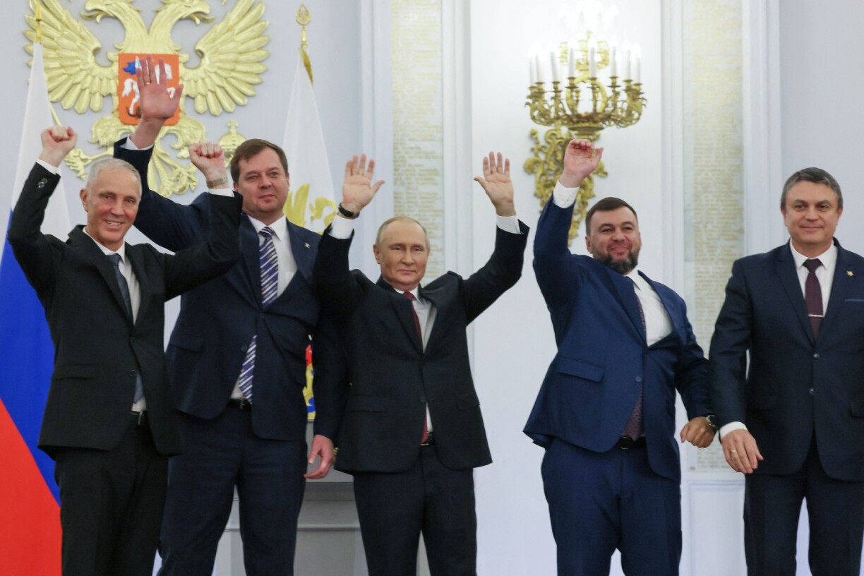 (L-R) The Moscow-appointed heads of Kherson region Vladimir Saldo and Zaporizhzhia region Yevgeny Balitsky, Russian President Vladimir Putin, Donetsk separatist leader Denis Pushilin and Lugansk separatist leader Leonid Pasechnik react after signing treaties formally annexing four regions of Ukraine Russian troops occupy.