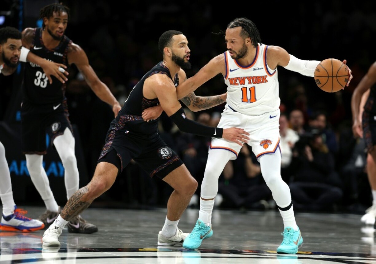 New York's Jalen Brunson, right, goes against Brooklyn's Tyrese Martin and the Knicks went on to defeat the host Nets in an NBA contest