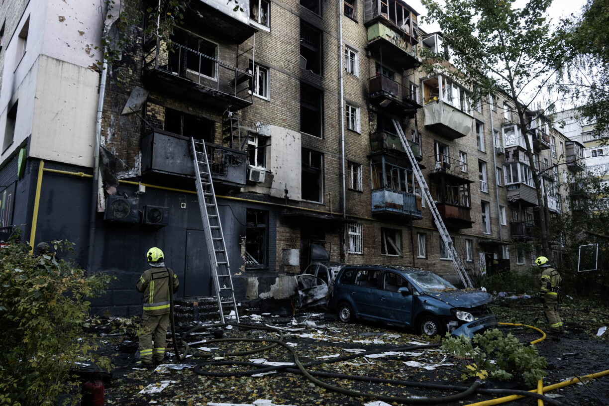 Rescuers work outside a damaged five-story residential building following a Russian drone attack in Kyiv on October 7, 2026, amid the Russian invasion of Ukraine. (Photo by Vladyslav Musiienko / AFP)