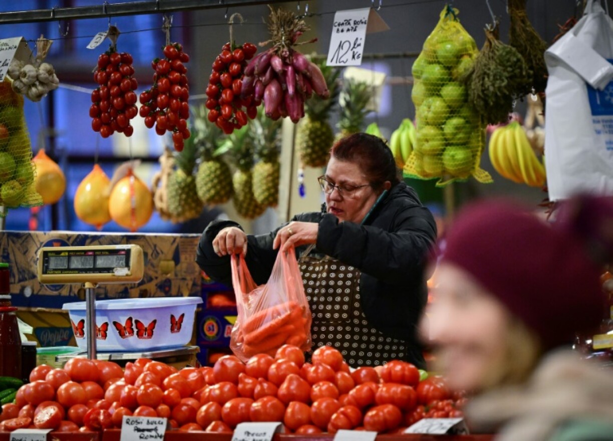 A vendor fills a bag with carrots at Piata Obor marketplace in Bucharest