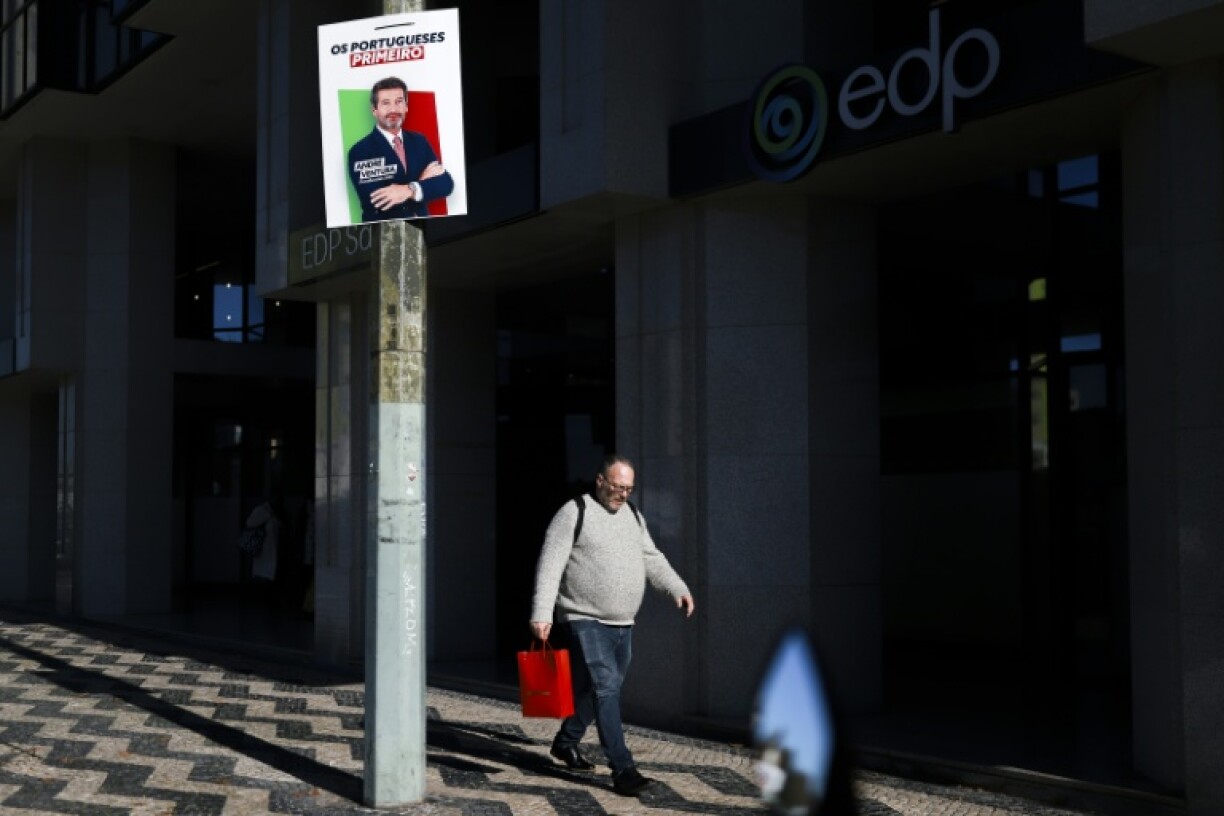 Un homme passe devant une affiche électorale du candidat à la présidence André Ventura, du parti d'extrême droite Chega, à Lisbonne, le 5 janvier 2026