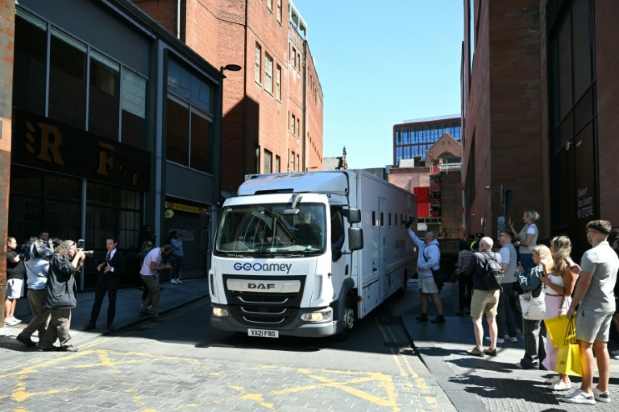 Members of the public and photographers look on as a prison van leaves from the back of a Manchester court shortly after US R&B singer Chris Brown was charged with a 2023 assault in a London nightclub