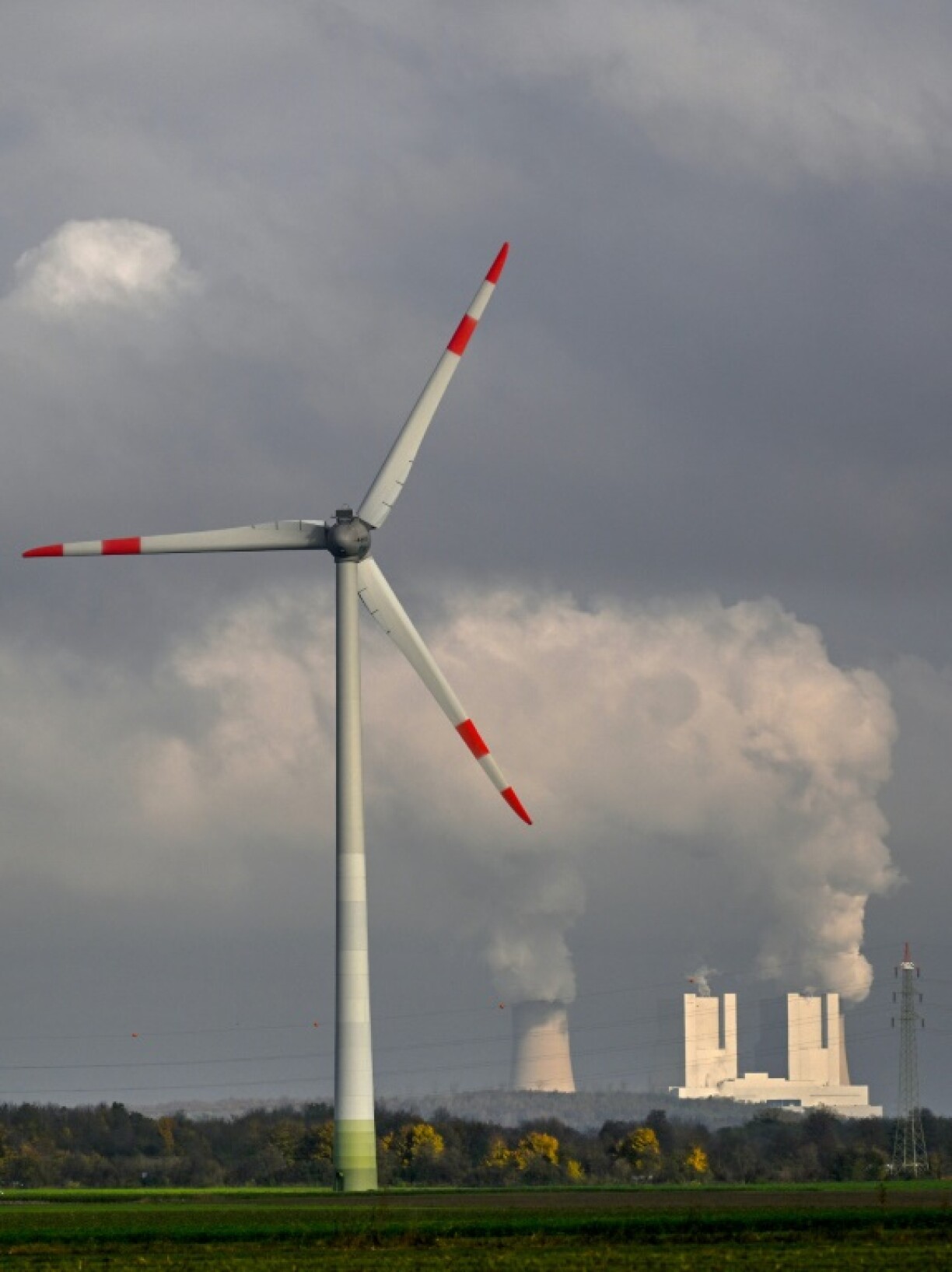 A wind turbine in front of a lignite-fired power station near Neurath, western Germany