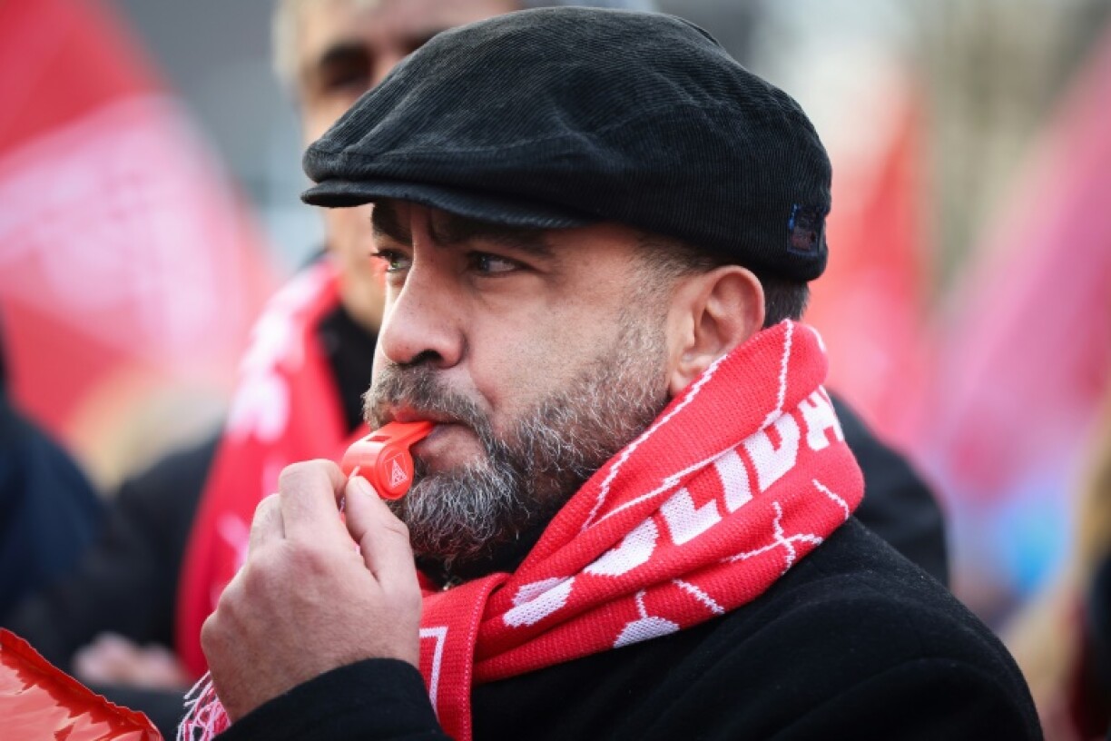 An employee of German car maker Volkswagen demonstrates outside the VW plant in Hanover, northern Germany