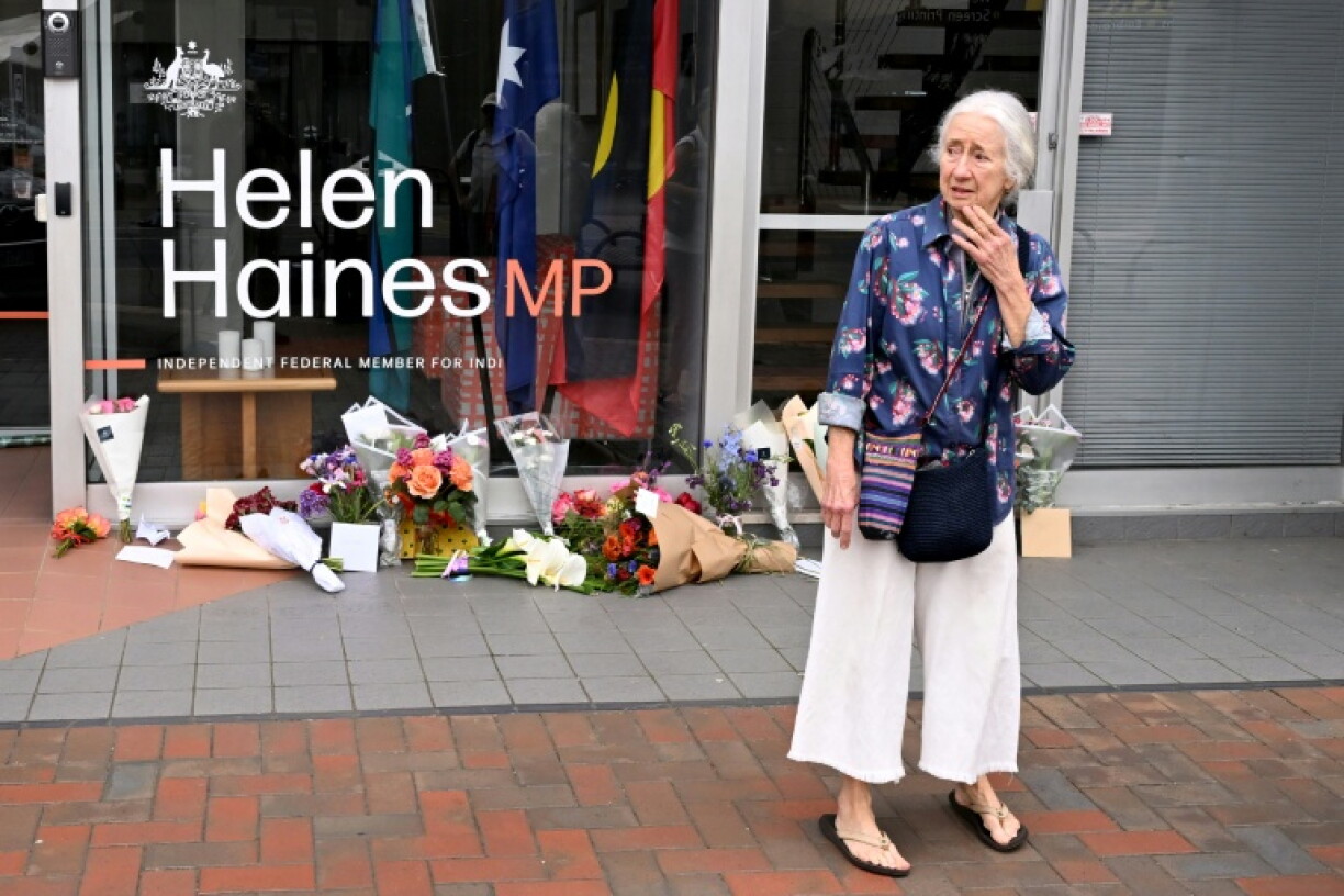 A woman reacts after laying flowers outside the office of Australian politician Helen Haines.