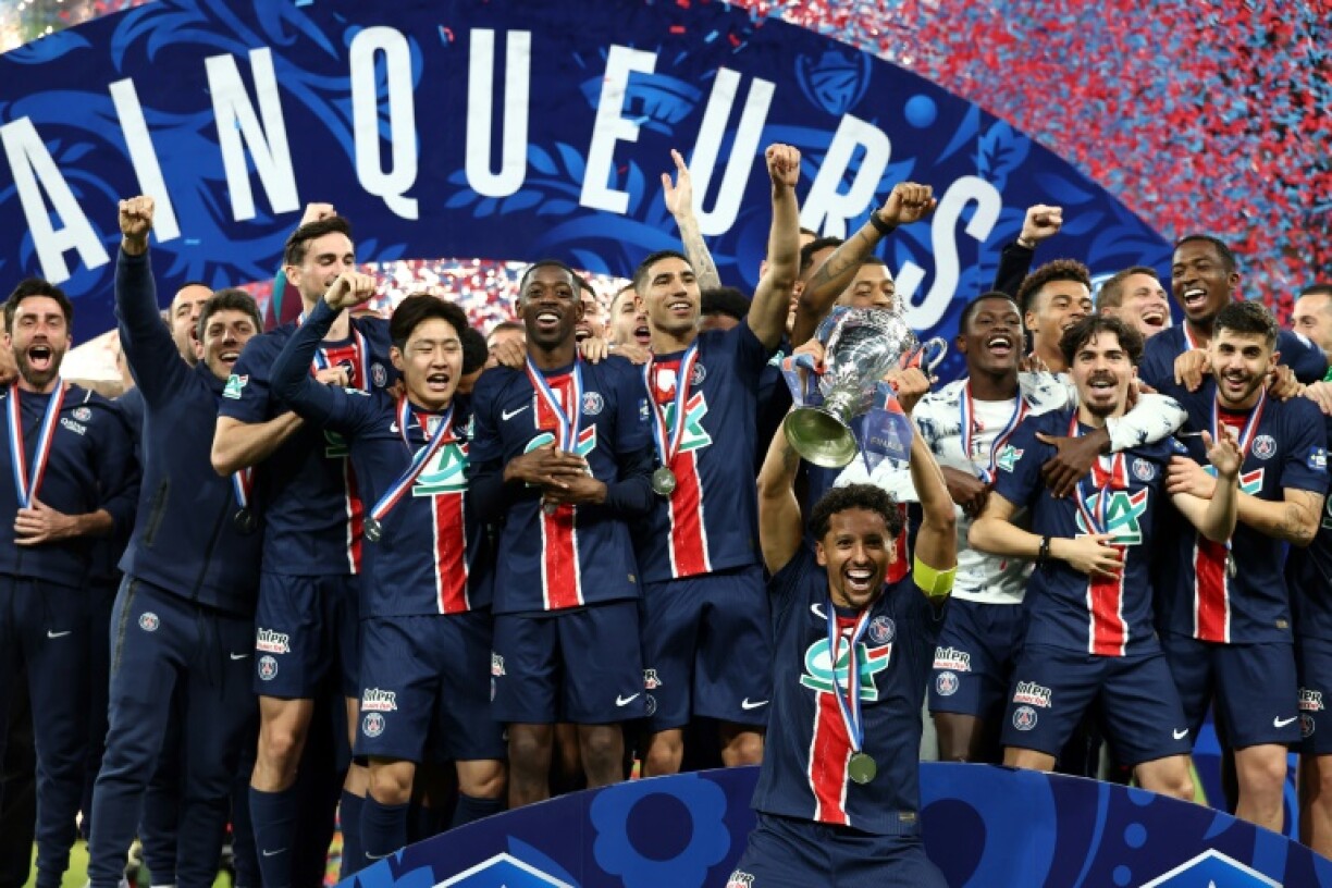 Paris Saint-Germain captain Marquinhos raises the French Cup aloft after his team's 3-0 win over Reims in Saturday's final