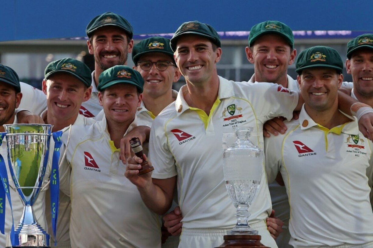 Australia's Pat Cummins (C) holds the urn trophy as Australia celebrate retaining The Ashes in 2023