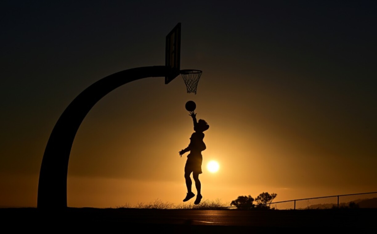 A boy shoots hoops at sunset on August 19, 2025 in San Pedro, California amid a brutal heat wave