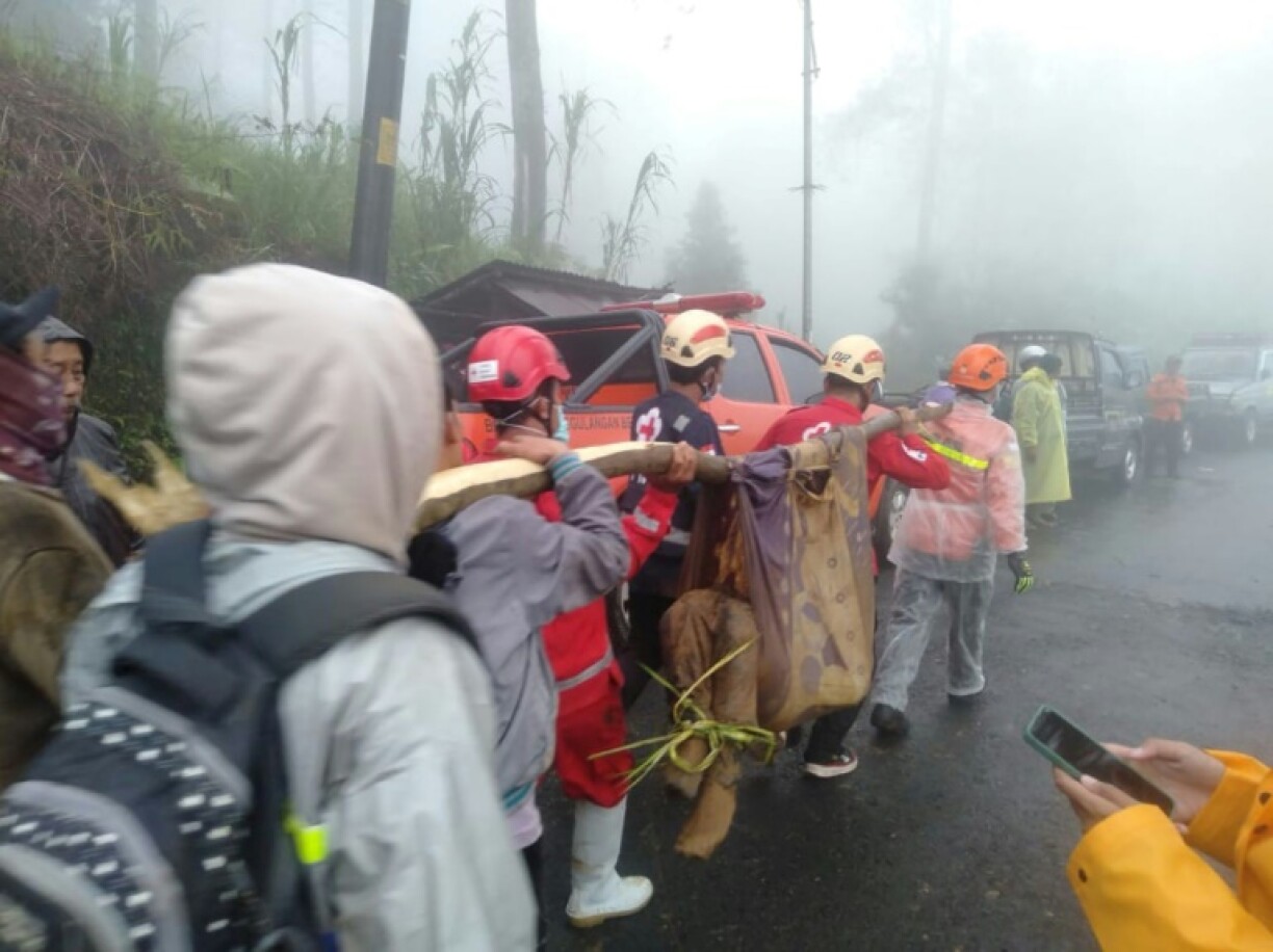Rescuers and villagers evacuate victims of a landslide in Pekalongan, Central Java that killed at least 16 people