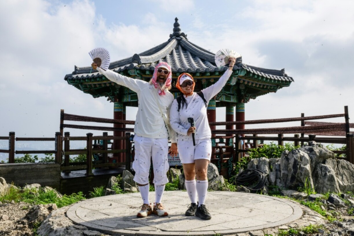 The lovebugs have attracted YouTubers like Sam Jung (L) and Kim Ji-young who film themselves covered in swarms of the insects