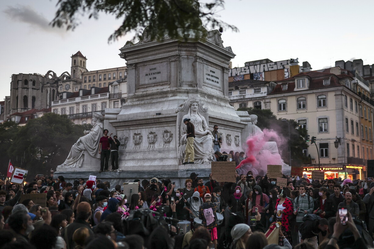 Des personnes se rassemblent, brandissant des drapeaux et scandant des slogans, lors d’une manifestation contre la pénurie de logements, la flambée des loyers et les bas salaires, sur la place du Rossio à Lisbonne, le 20 octobre 2026.