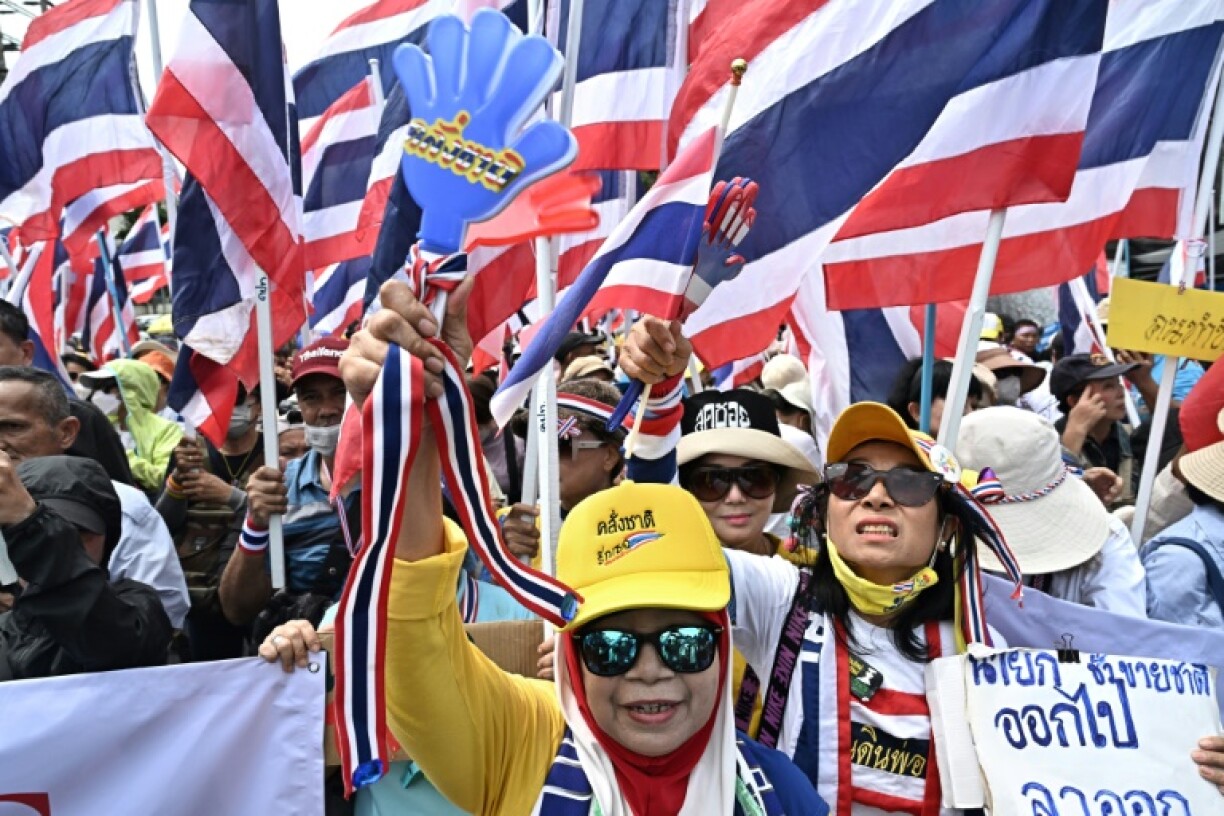 Anti-government protesters hold Thai national flags during a demonstration to demand the removal of Thailand's Prime Minister Paetongtarn Shinawatra from office outside Government House in Bangkok