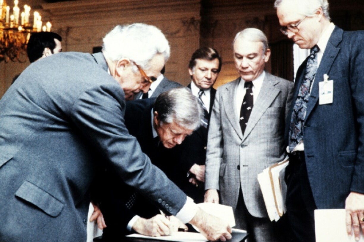 President Jimmy Carter signs an order blocking Iranian funds in US banks in November 1979, days after Iranian students stormed the US embassy in Tehran, taking US hostages