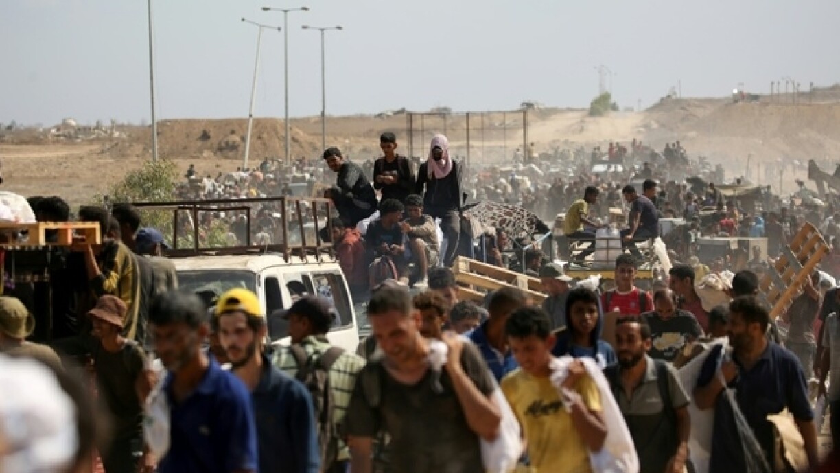 Des Palestiniens revenant d'un site de distribution d'aide de la Fondation humanitaire à Gaza (GHF) soutenue par Israël et les Etats-Unis, dans le centre de la Bande de Gaza, le 3 août 2025