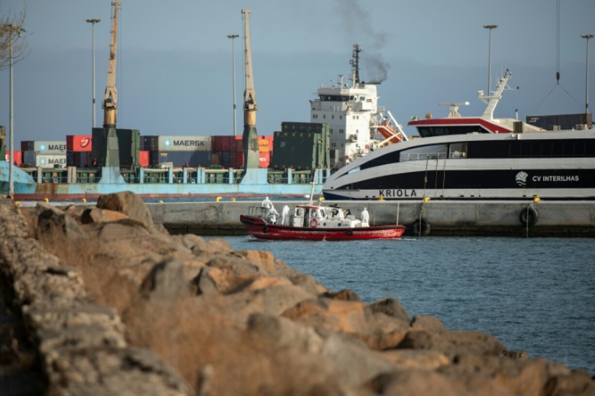 Un bateau-ambulance transportant des membres d'équipage en combinaisons de protection retourne au port de Praia, après une visite à bord du bateau de croisière MV Hondius, au mouillage au large du port, le 5 mai 2026 au Cap-Vert