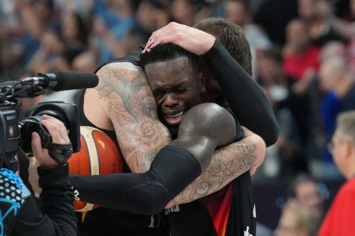 An emotional Dennis Schroeder (R) slumped to the floor as his teammates mobbed him after the high-quality match ended