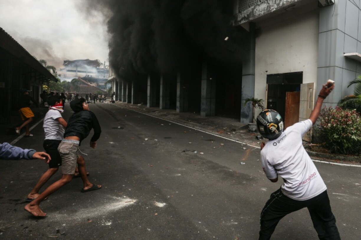 Protesters throw stones at a local council building on Lombok island