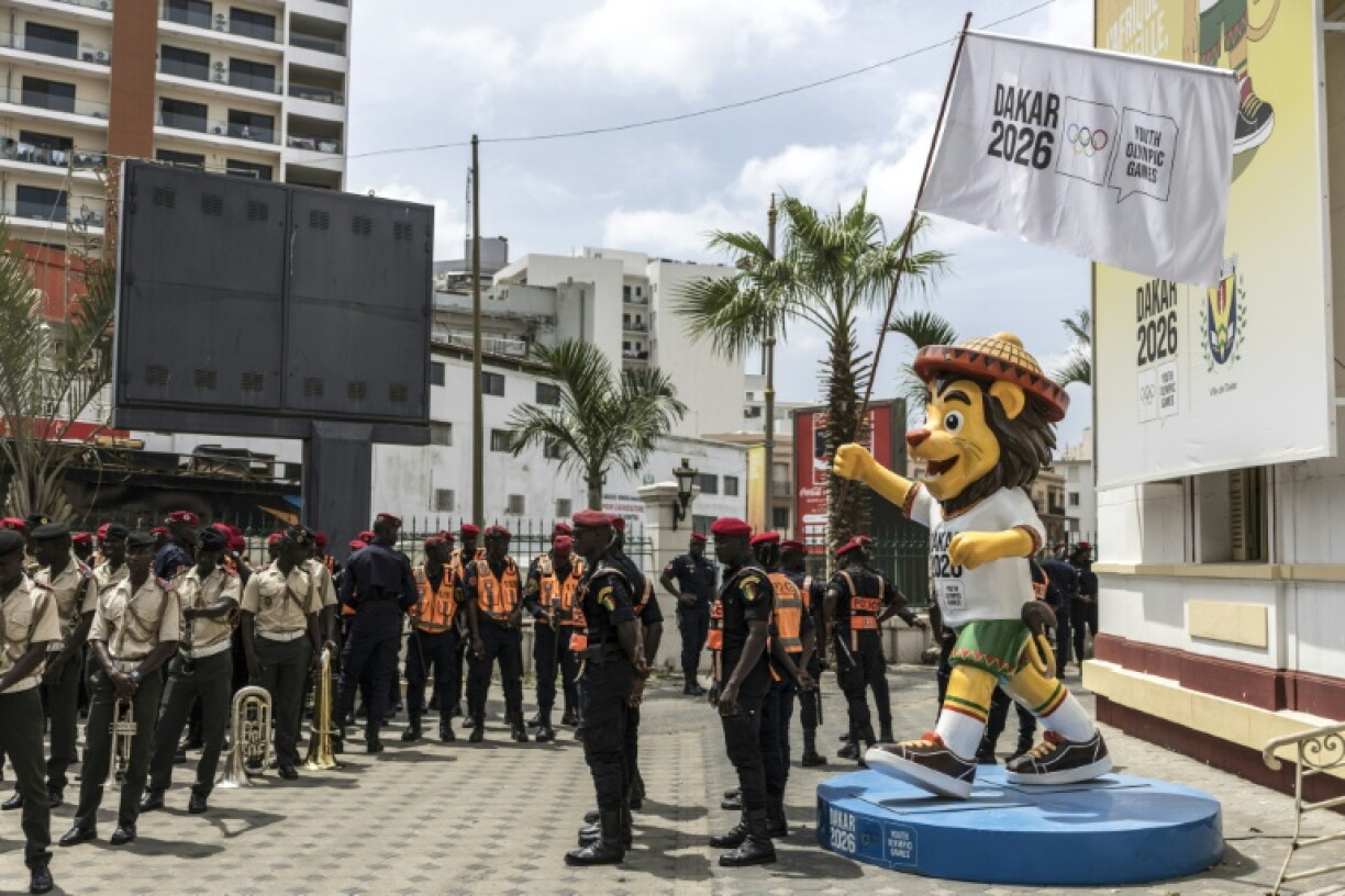 Police stand in formation next to a statue of Ayo, Senegal’s Youth Olympics Games mascot