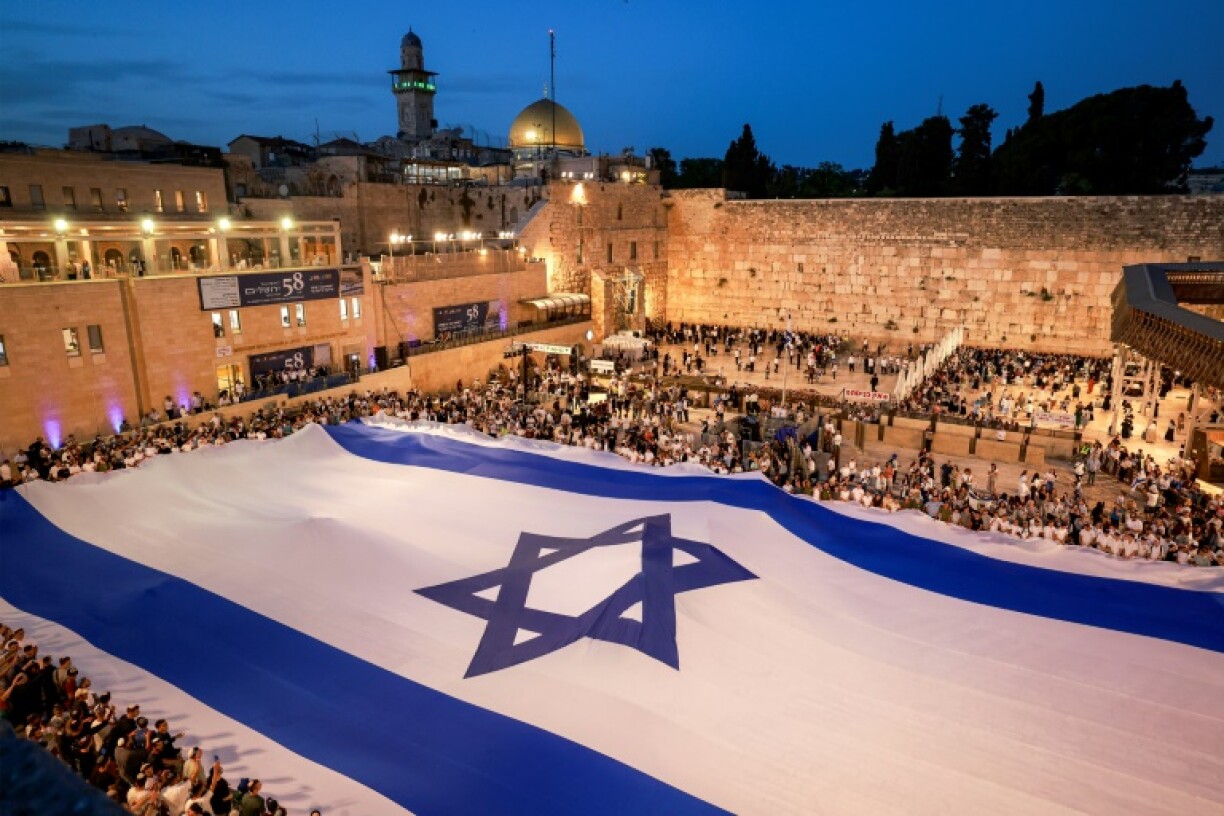 People unfurl a giant Israeli flag at the Western Wall on the eve of Jerusalem Day, which marks the Israeli army's 1967 capture of the city's eastern sector