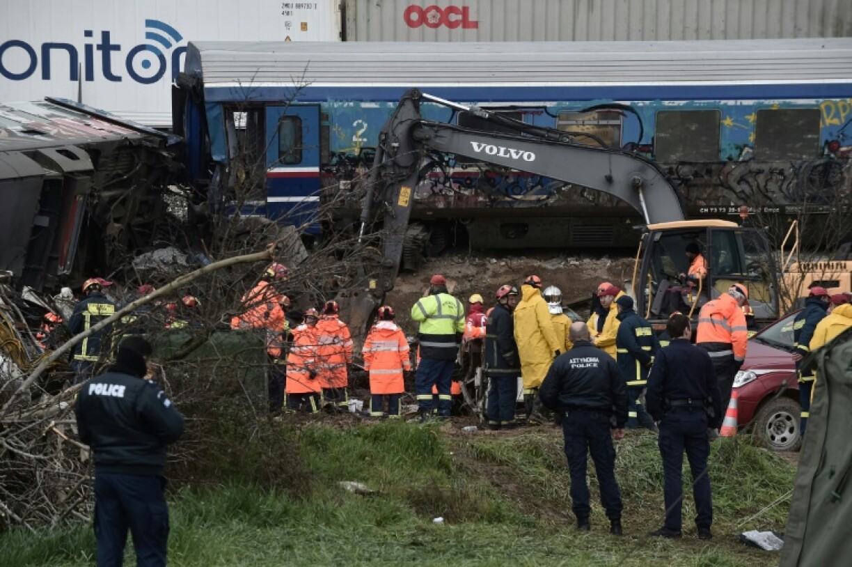Des équipes de police et de secours examinent les débris d'un wagon, deux jours après une collision entre deux trains, le 2 mars 2023 près de Larissa, en Grèce