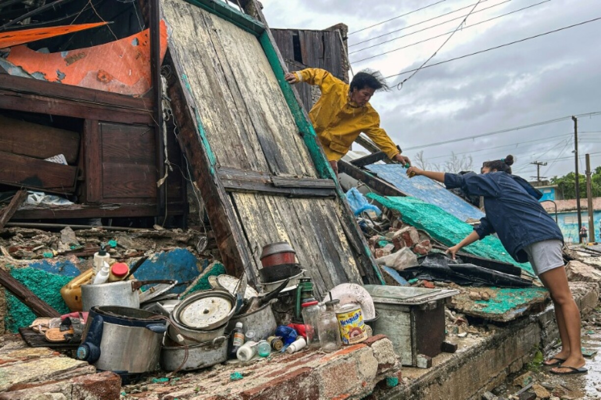 A family salvages belongings from the rubble of their home after it collapsed during Hurricane Melissa’s passage through Santiago de Cuba, Cuba